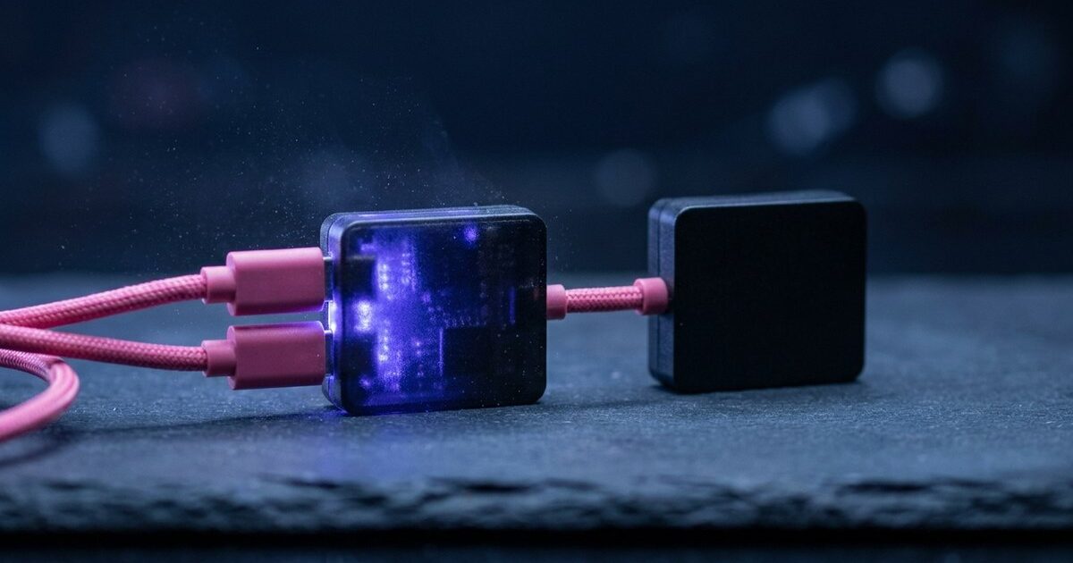 Two identical modules joined by a short jumper cable, one glowing indigo and one dark and waiting